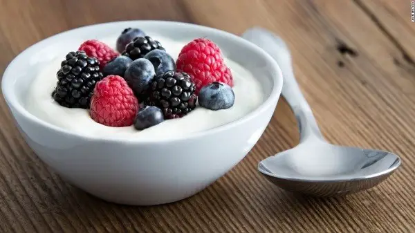 Yogurt in a bowl with berries on it.